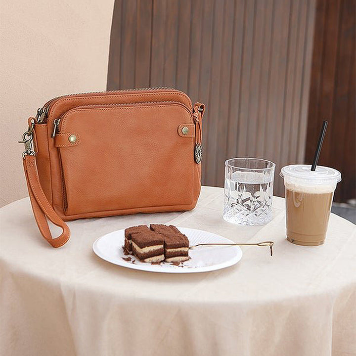 "Brun läder damväska, multifunktionell crossbody, elegant design, rymmer iPad, med RFID-skydd, modern look."