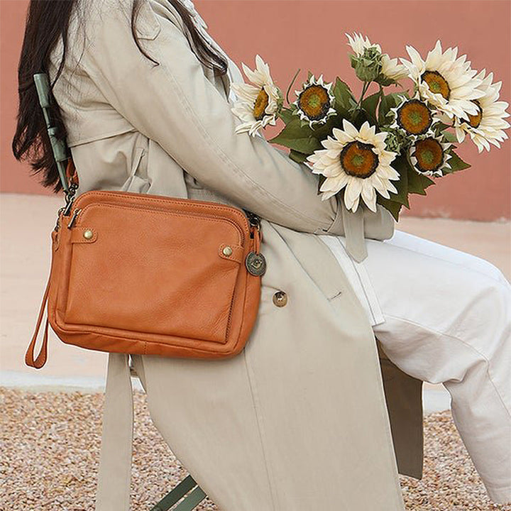 "Brun läder damväska, multifunktionell crossbody, elegant design, rymmer iPad, med RFID-skydd, modern look."
