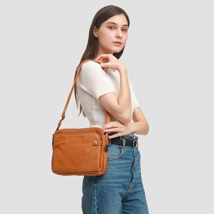 "Brun läder damväska, multifunktionell crossbody, elegant design, rymmer iPad, med RFID-skydd, modern look."