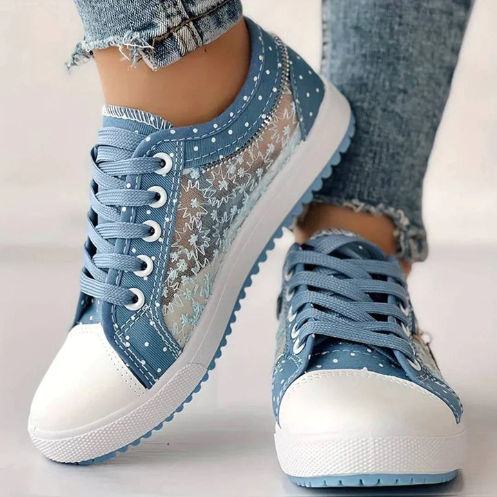 Detaljbild av Celina damsneakers, fokus på den eleganta blommiga spetsen. Perfekta vårskor.