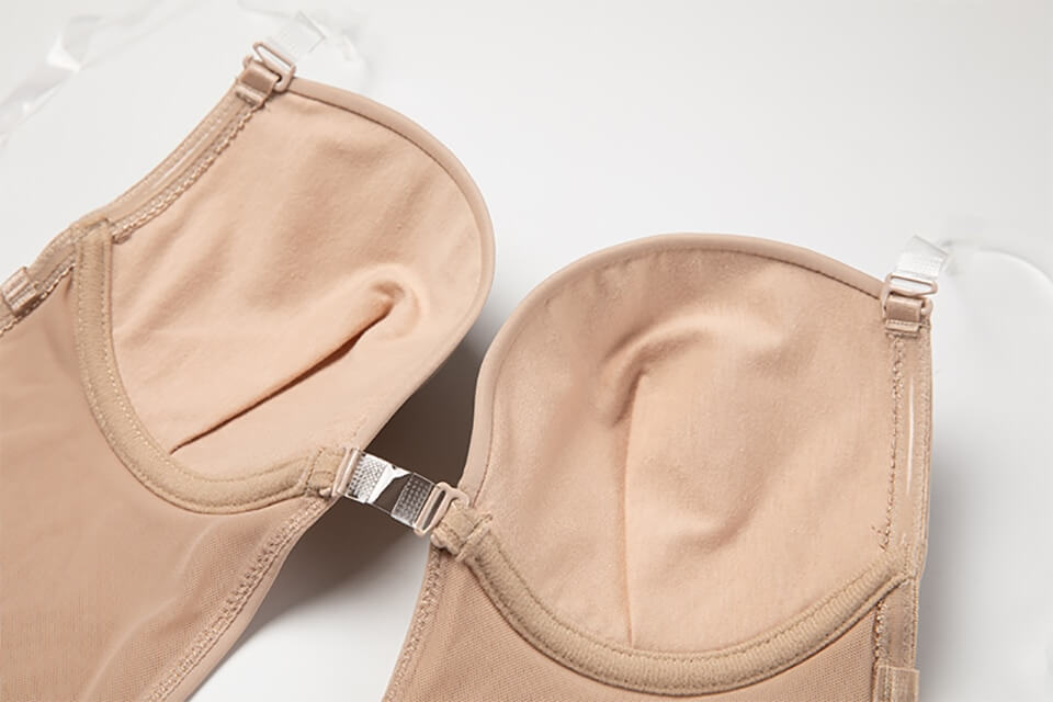 Modell bär rygglös body shaper under en klänning. Visar hur den skapar en osynlig & formande siluett för dam.