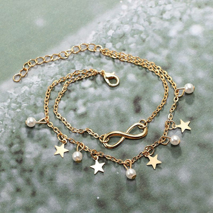 Dam boho ankelarmband i silver och guld, elegant design med geometriska former, perfekt för stil och komfort.