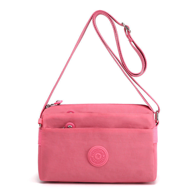 "Dam casual nylon crossbody väska i flerfärgat mönster med justerbar rem och flera fack, stilren design."