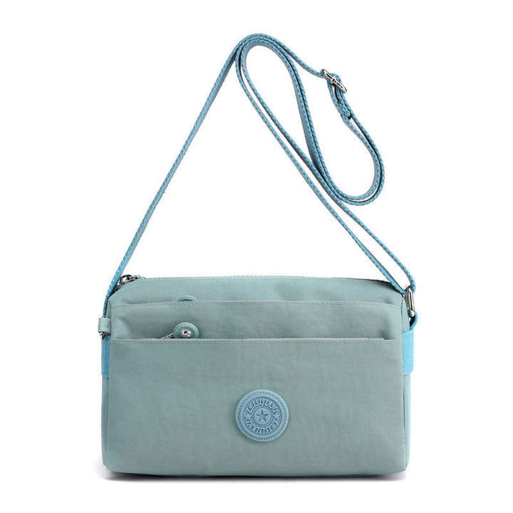 "Dam casual nylon crossbody väska i flerfärgat mönster med justerbar rem och flera fack, stilren design."