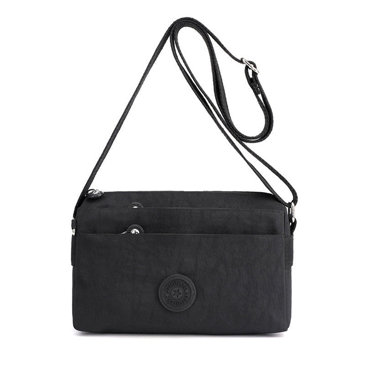 "Dam casual nylon crossbody väska i flerfärgat mönster med justerbar rem och flera fack, stilren design."