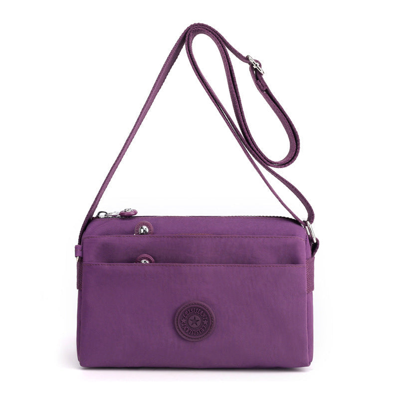 "Dam casual nylon crossbody väska i flerfärgat mönster med justerbar rem och flera fack, stilren design."