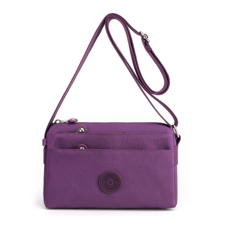 "Dam casual nylon crossbody väska i flerfärgat mönster med justerbar rem och flera fack, stilren design."