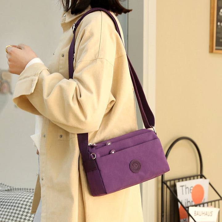 "Dam casual nylon crossbody väska i flerfärgat mönster med justerbar rem och flera fack, stilren design."