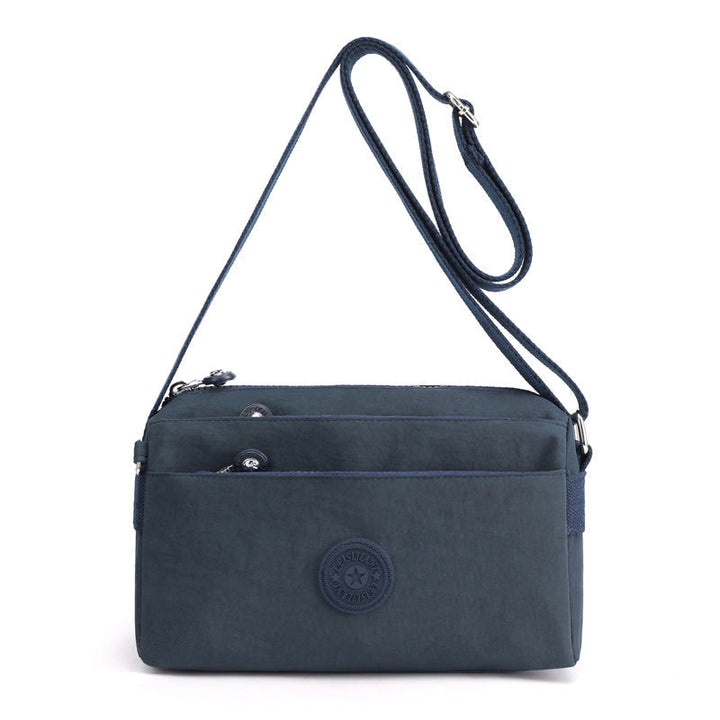 "Dam casual nylon crossbody väska i flerfärgat mönster med justerbar rem och flera fack, stilren design."