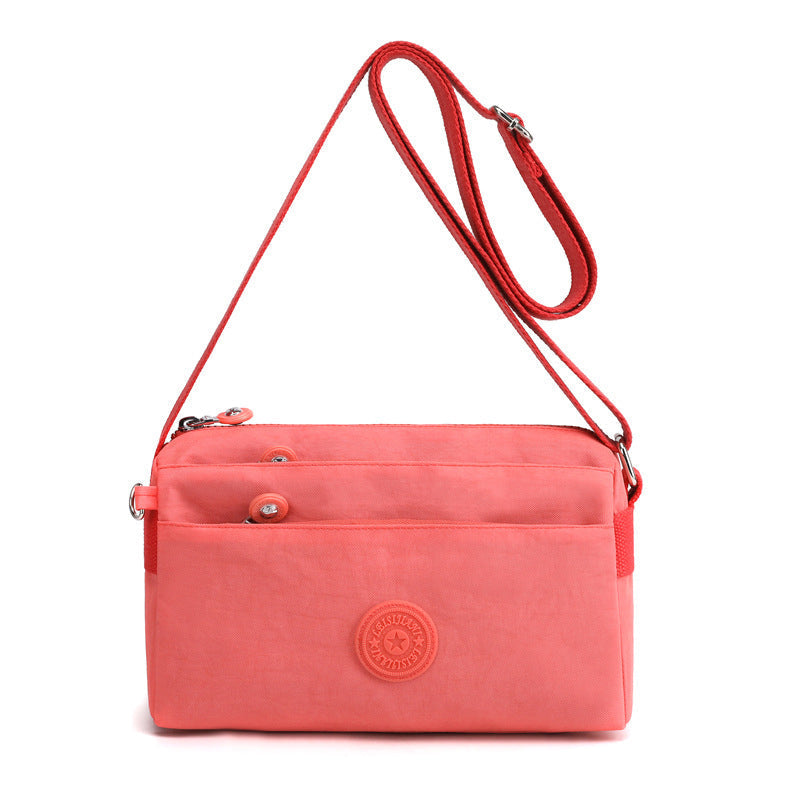 "Dam casual nylon crossbody väska i flerfärgat mönster med justerbar rem och flera fack, stilren design."