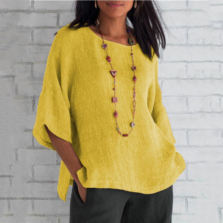 "Dam enfärgad blus med rund hals och trekvartsärm, stilren design och mjukt material för elegant och bekväm look."