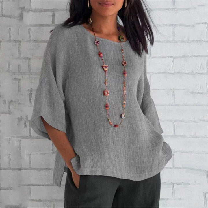 "Dam enfärgad blus med rund hals och trekvartsärm, stilren design och mjukt material för elegant och bekväm look."