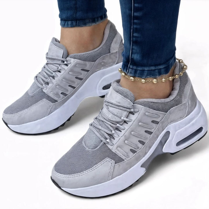 Kvinna bär stilrena, lätta slip-on sneakers. Bekväma dam vardagsskor med bra fotstöd.