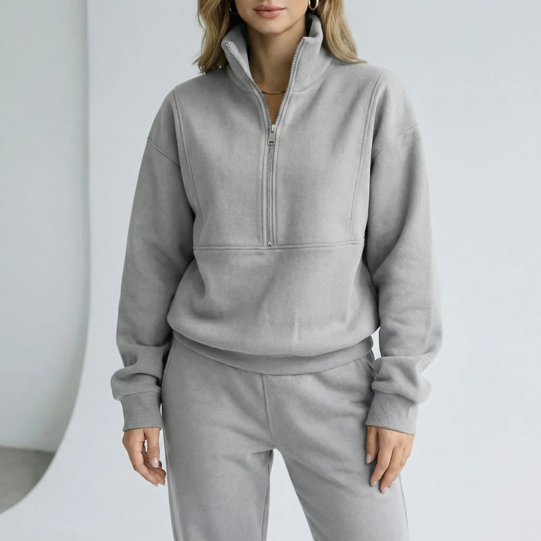 Dam Alexis loungewear set med vid passform, mjuk tröja med halvdragkedja och matchande byxor.