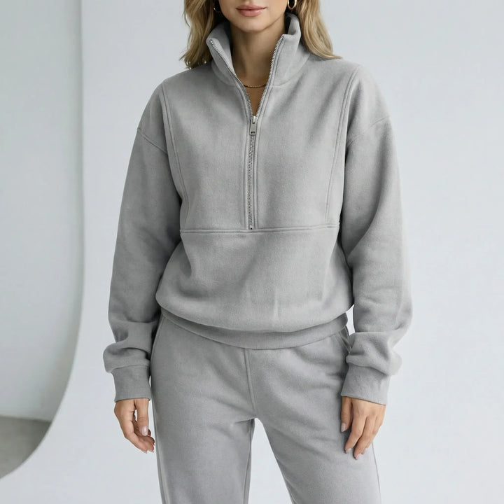 Dam Alexis loungewear set med vid passform, mjuk tröja med halvdragkedja och matchande byxor.