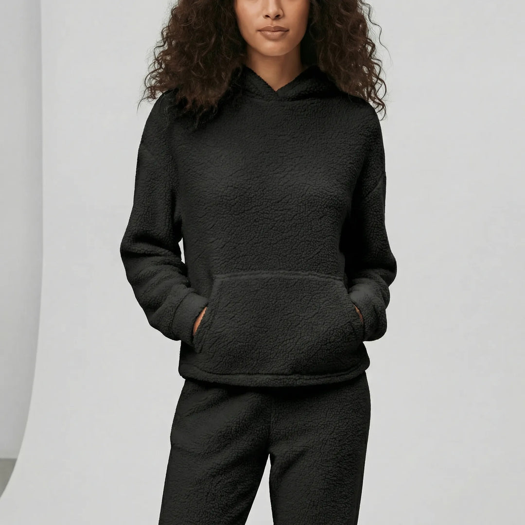 Kvinna bär bekvämt dam loungewear-set Milana. Hoodie med huva & byxor. Mjuka myskläder för avslappnad stil.