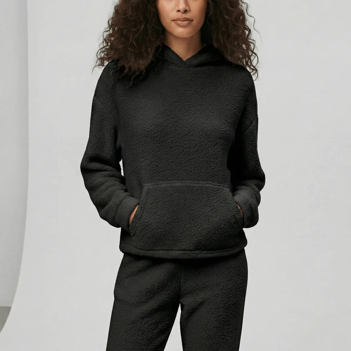 Kvinna bär bekvämt dam loungewear-set Milana. Hoodie med huva & byxor. Mjuka myskläder för avslappnad stil.