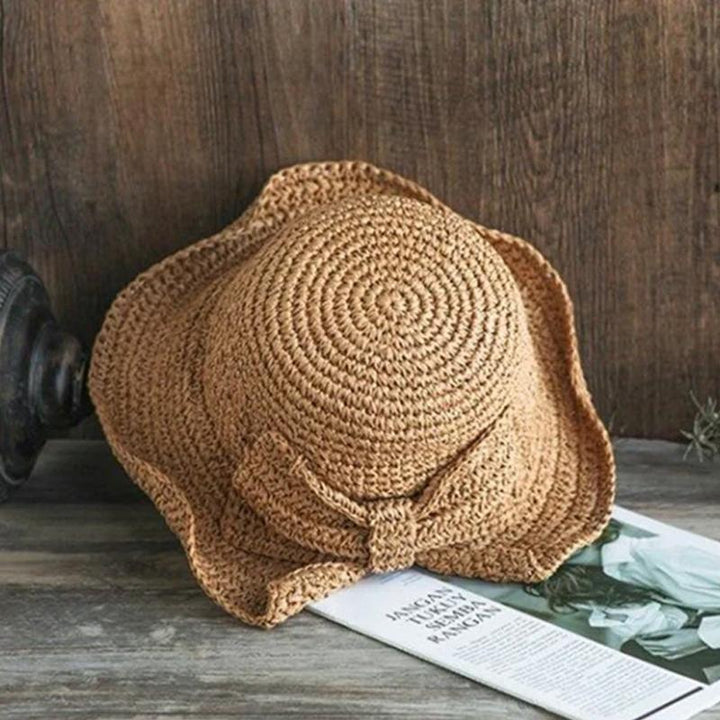 "Dam sommarhatt med rosett i pastellfärger, ventilerande och elegant för stil och komfort i sommarvärmen."