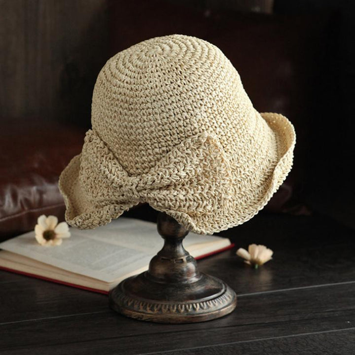 "Dam sommarhatt med rosett i pastellfärger, ventilerande och elegant för stil och komfort i sommarvärmen."