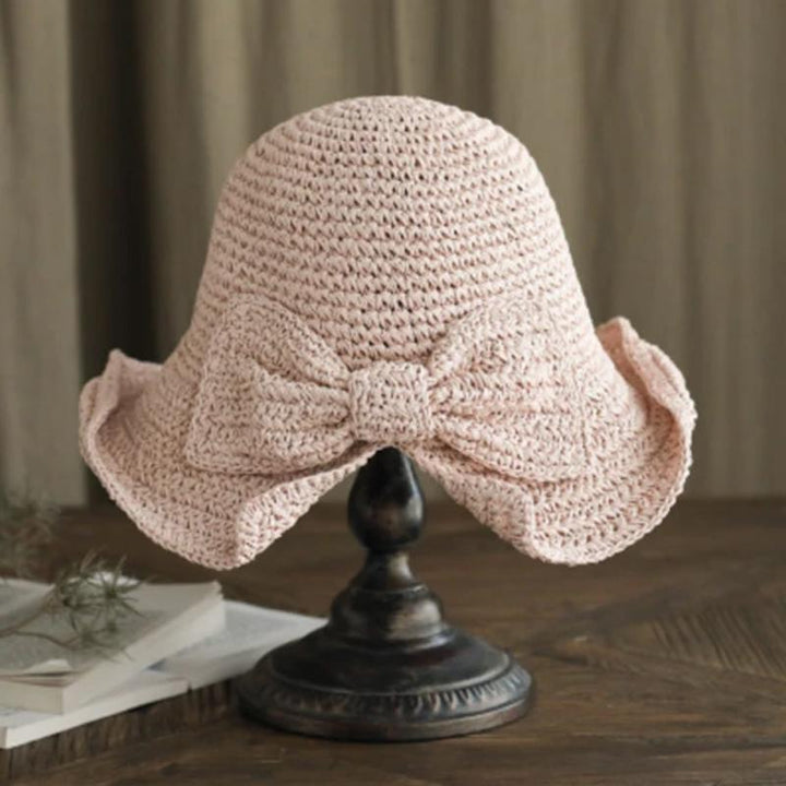 "Dam sommarhatt med rosett i pastellfärger, ventilerande och elegant för stil och komfort i sommarvärmen."