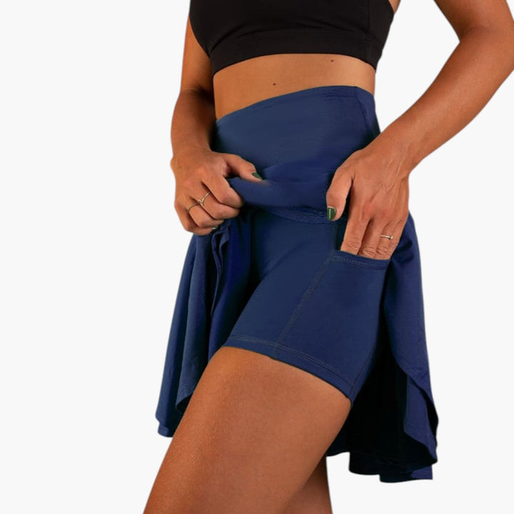 Utställd dam träningskjol i minilängd med praktiska inbyggda shorts och hög midja för aktiv fritid.