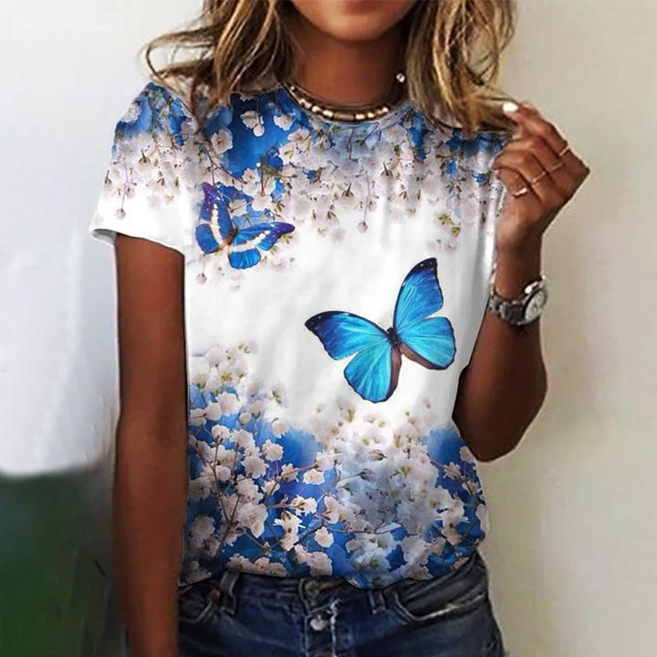 "Dam t-shirt med rund hals och kort ärm; grafiktryck av blommor och fjärilar, perfekt för vardagsbruk."