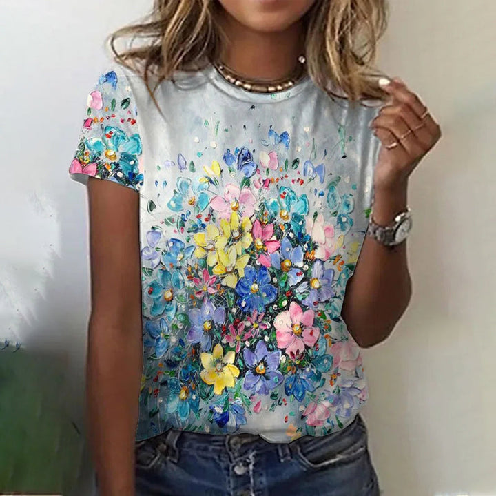 "Dam t-shirt med rund hals och kort ärm; grafiktryck av blommor och fjärilar, perfekt för vardagsbruk."