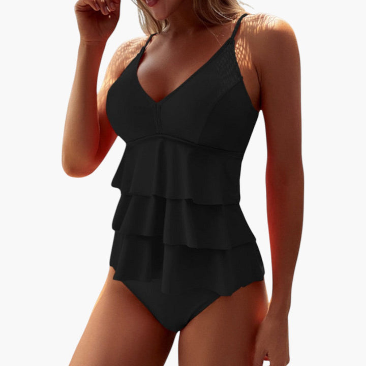 Modell i dam tankini med justerbara axelband och standard midjebotten, visar stilren sommarlook.