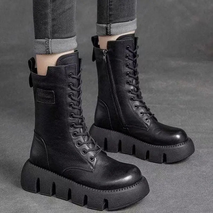 Svarta höga dam platå-kampsstövlar med snörning. Trendiga och bekväma för dammode.
