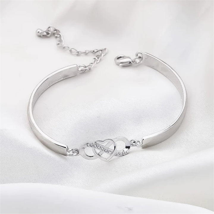 "Damarmband i roseguld och silver med hjärtberlock visar kärlek, stil och elegans. Perfekt present till mamma."