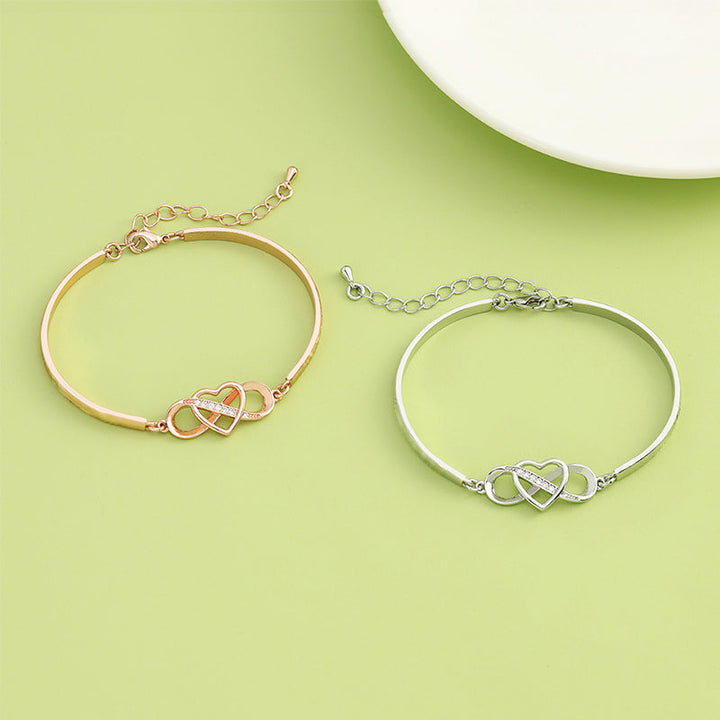 "Damarmband i roseguld och silver med hjärtberlock visar kärlek, stil och elegans. Perfekt present till mamma."