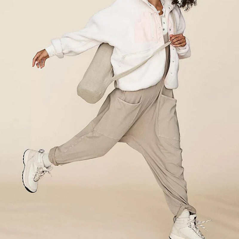 "Dambyxa i enfärgad V-neck jumpsuit med fickor, stilren och elegant design för vardaglig och avslappnad användning."
