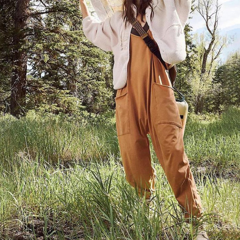 "Dambyxa i enfärgad V-neck jumpsuit med fickor, stilren och elegant design för vardaglig och avslappnad användning."