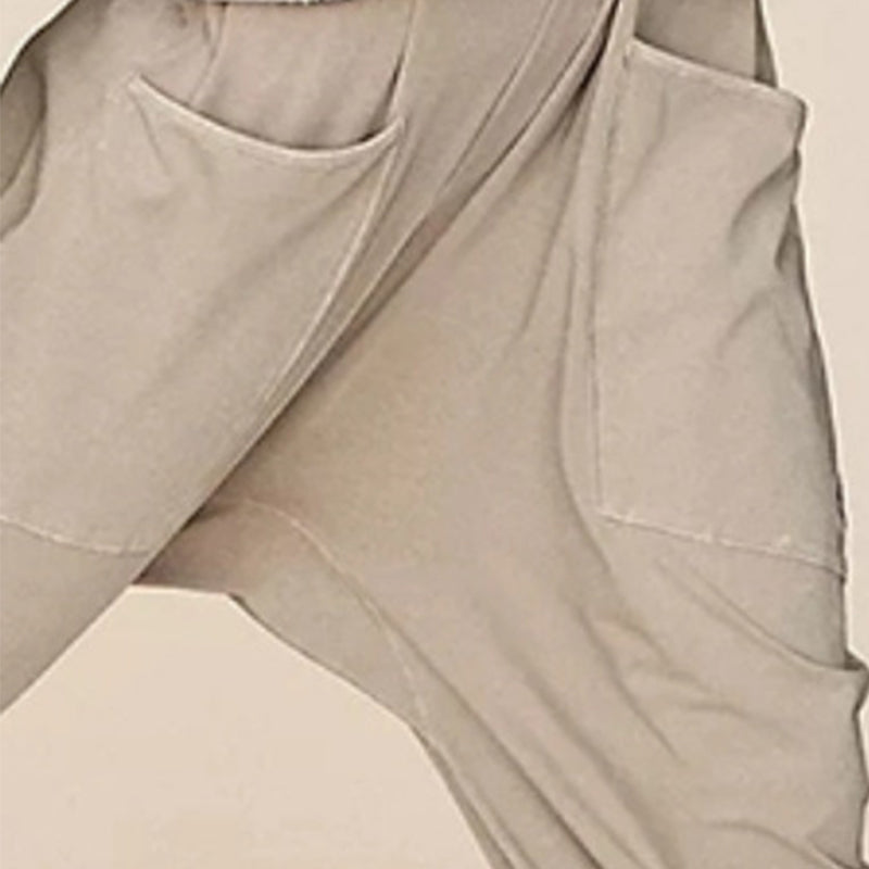 "Dambyxa i enfärgad V-neck jumpsuit med fickor, stilren och elegant design för vardaglig och avslappnad användning."