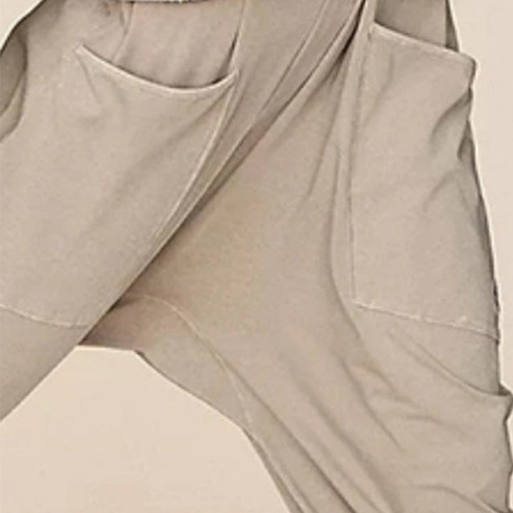 "Dambyxa i enfärgad V-neck jumpsuit med fickor, stilren och elegant design för vardaglig och avslappnad användning."