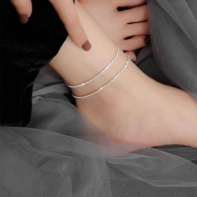 "Dambyxa i glittrande silver med glitterkedja, skimrande design för elegans och stil, perfekt accessoar för kvinnor."