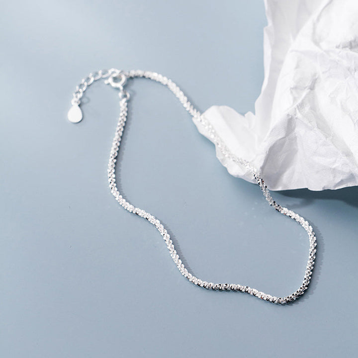 "Dambyxa i glittrande silver med glitterkedja, skimrande design för elegans och stil, perfekt accessoar för kvinnor."