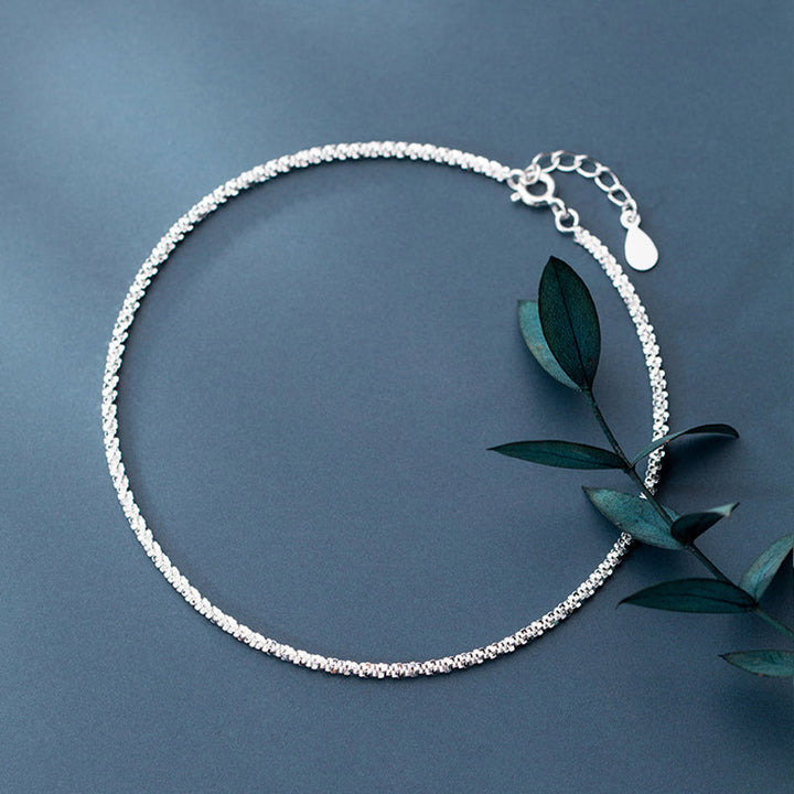 "Dambyxa i glittrande silver med glitterkedja, skimrande design för elegans och stil, perfekt accessoar för kvinnor."
