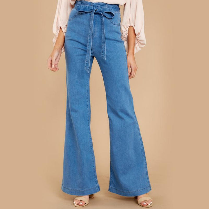 "Dambyxor i blå denim med hög midja och vida ben, ses med bälte för justerbar passform, eleganta och tidlösa."