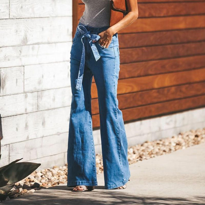 "Dambyxor i blå denim med hög midja och vida ben, ses med bälte för justerbar passform, eleganta och tidlösa."