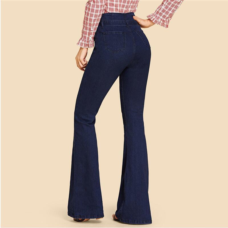 "Dambyxor i blå denim med hög midja och vida ben, ses med bälte för justerbar passform, eleganta och tidlösa."
