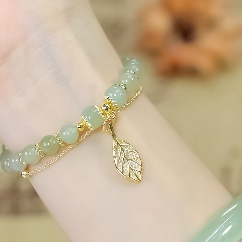 "Dame armband i grön jade med gulddekor, elegant smycke, grön sten och gyllene detaljer, perfekt accessoar för kvinnor."