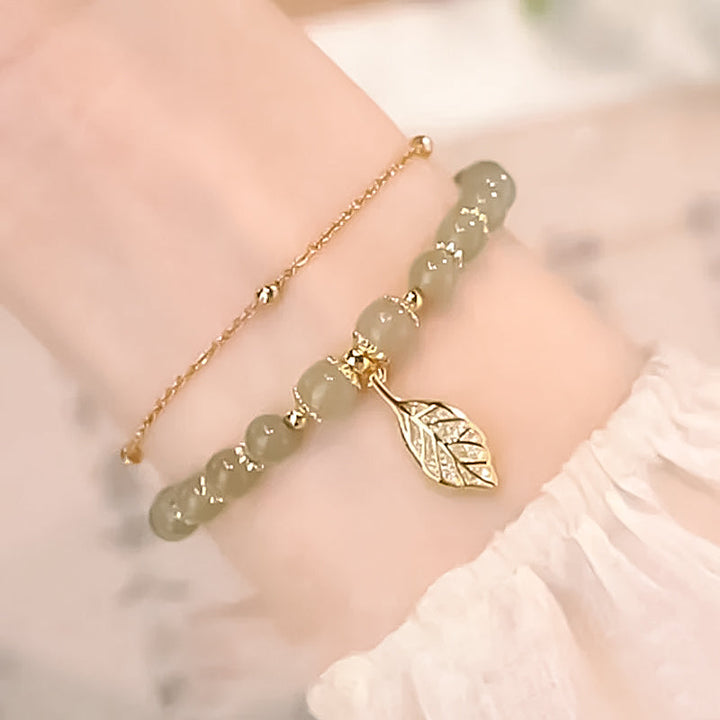 "Dame armband i grön jade med gulddekor, elegant smycke, grön sten och gyllene detaljer, perfekt accessoar för kvinnor."