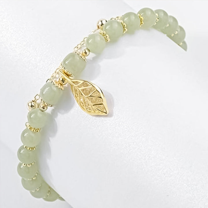 "Dame armband i grön jade med gulddekor, elegant smycke, grön sten och gyllene detaljer, perfekt accessoar för kvinnor."