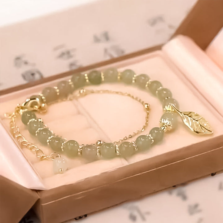 "Dame armband i grön jade med gulddekor, elegant smycke, grön sten och gyllene detaljer, perfekt accessoar för kvinnor."