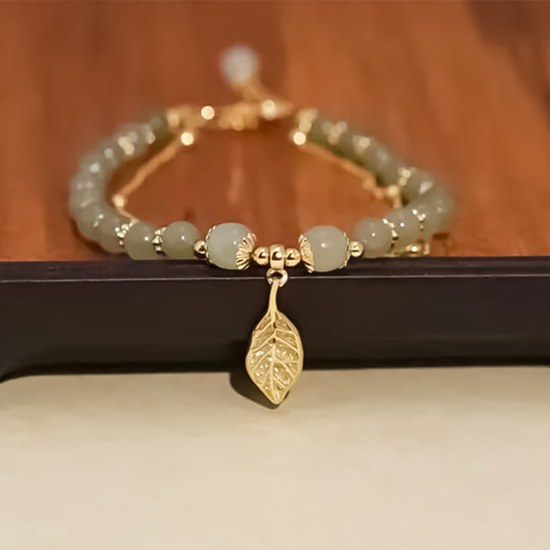 "Dame armband i grön jade med gulddekor, elegant smycke, grön sten och gyllene detaljer, perfekt accessoar för kvinnor."