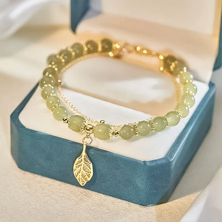 "Dame armband i grön jade med gulddekor, elegant smycke, grön sten och gyllene detaljer, perfekt accessoar för kvinnor."