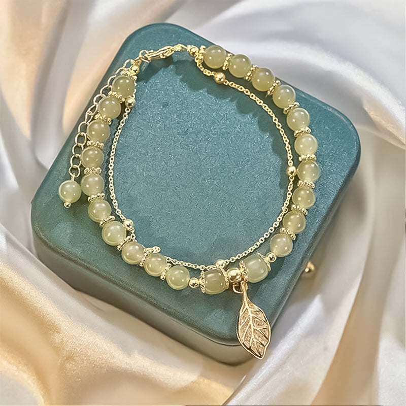 "Dame armband i grön jade med gulddekor, elegant smycke, grön sten och gyllene detaljer, perfekt accessoar för kvinnor."