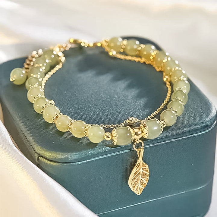 "Dame armband i grön jade med gulddekor, elegant smycke, grön sten och gyllene detaljer, perfekt accessoar för kvinnor."