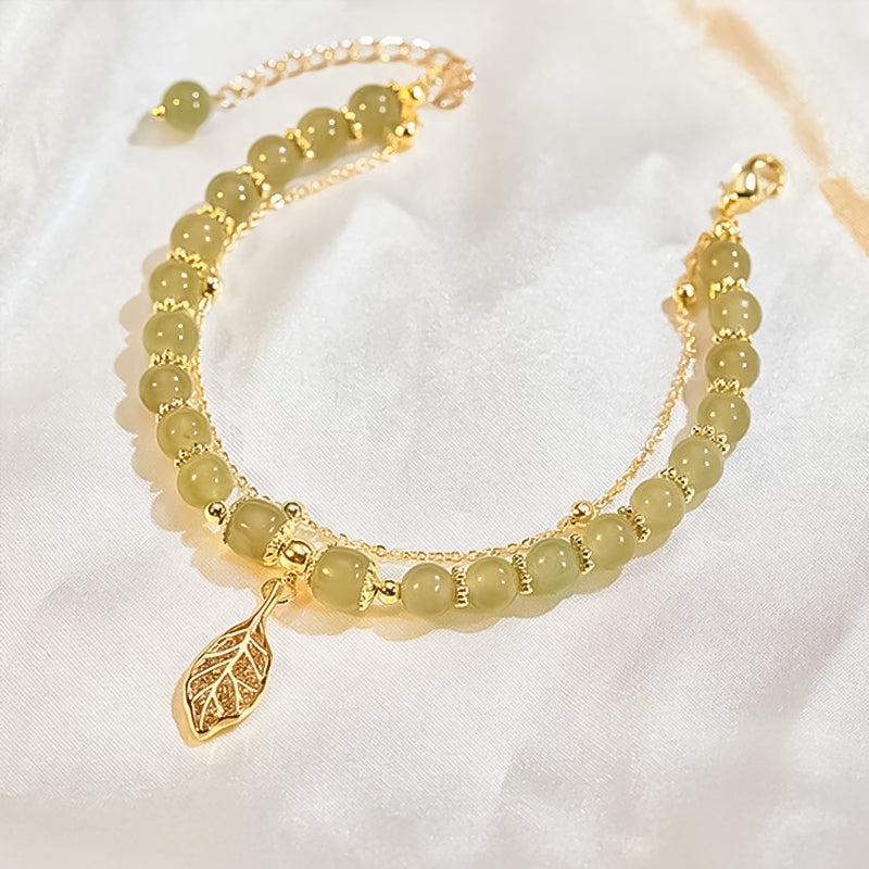 "Dame armband i grön jade med gulddekor, elegant smycke, grön sten och gyllene detaljer, perfekt accessoar för kvinnor."